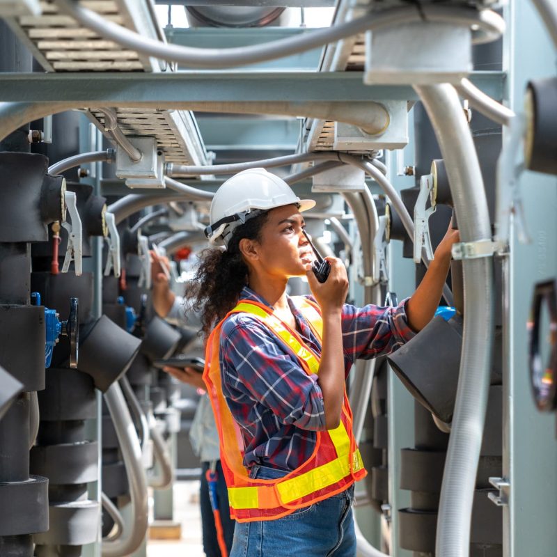 Vrouw met helm in machinekamer